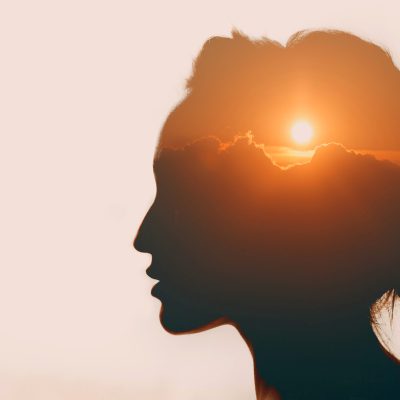 Woman with sun over clouds in her head. Mental health concept.